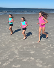 Girls actively running on beach with Neon Sporty Swim Separates